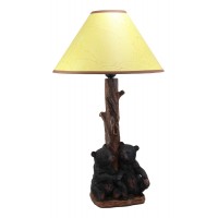 Two sibling black bear cubs sitting together with lamp statue