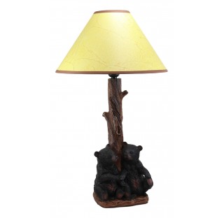 Two sibling black bear cubs sitting together with lamp statue